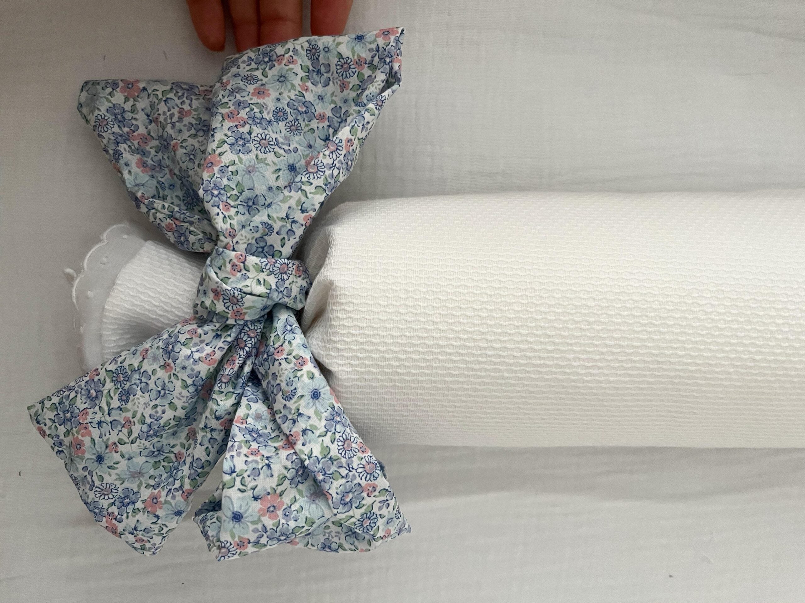 Cojín antivuelco piqué con lazo flores azules