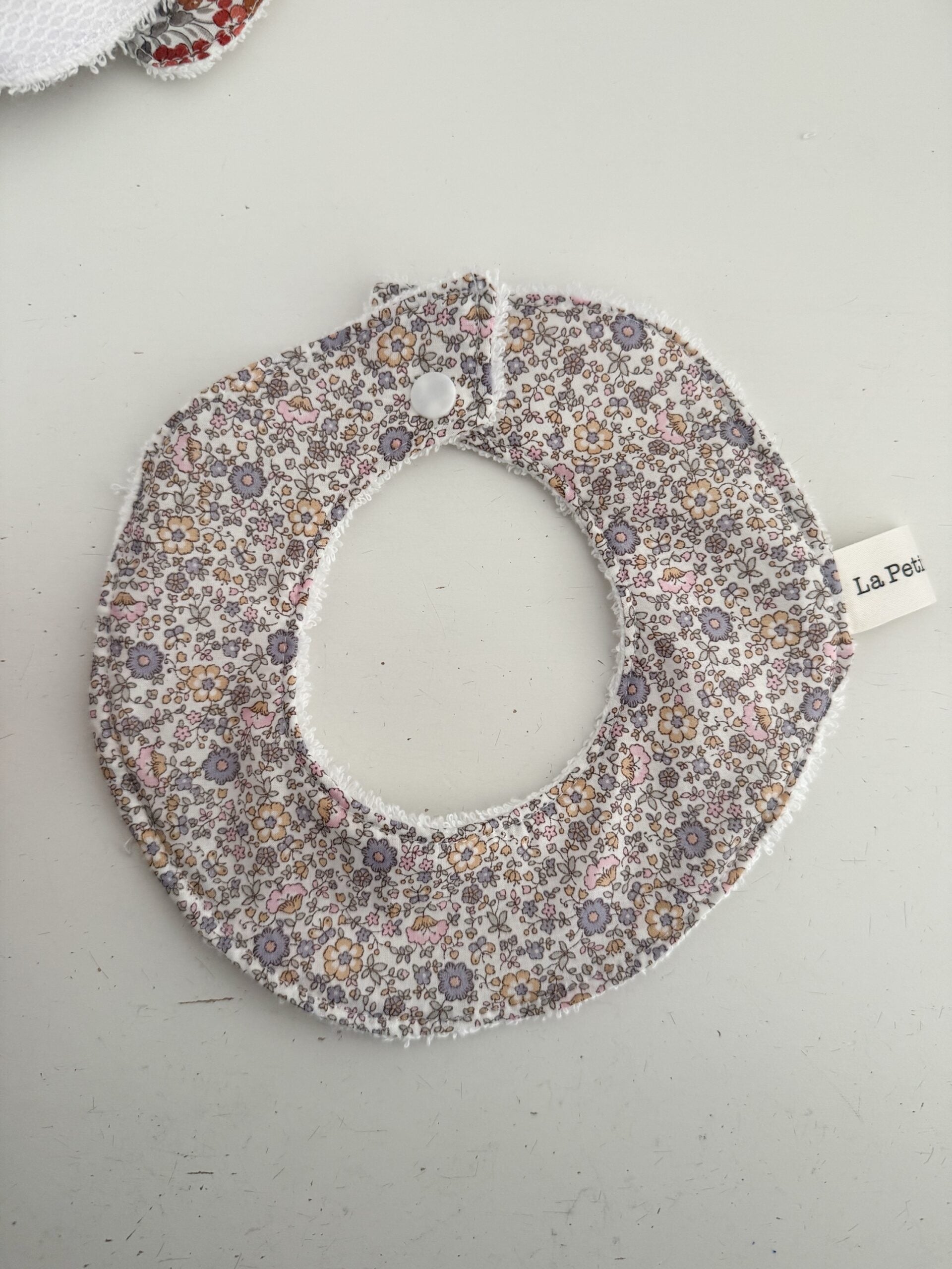 Cuello salvababas flor gris nude