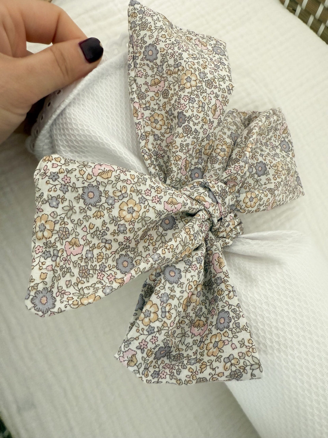 Cojín antivuelco piqué con lazo flor gris nude